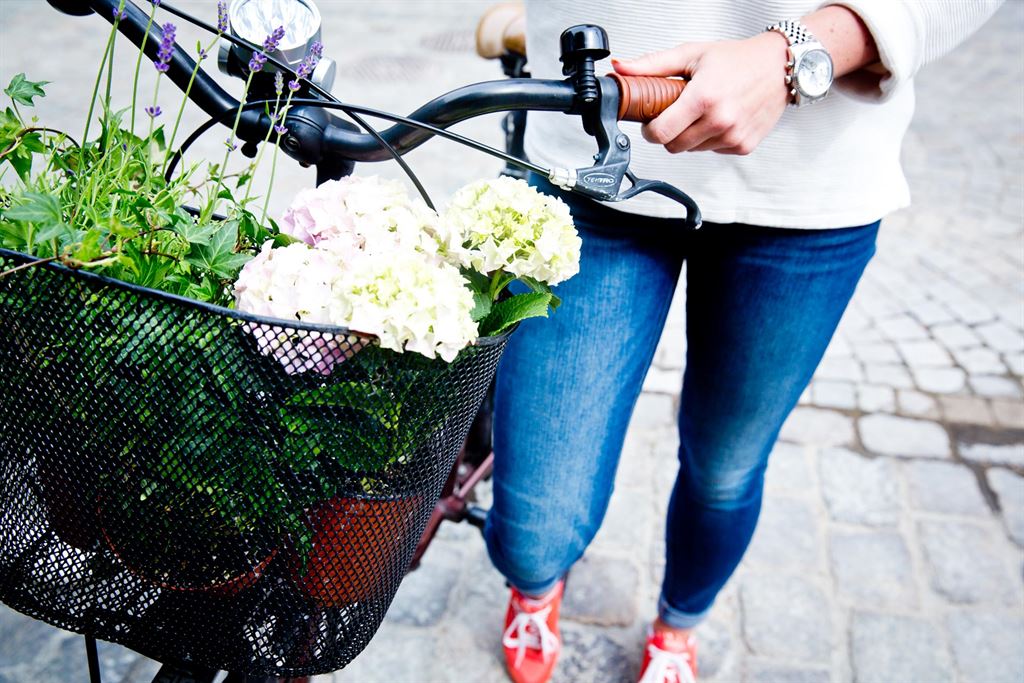 Kvinna som går med en cykel