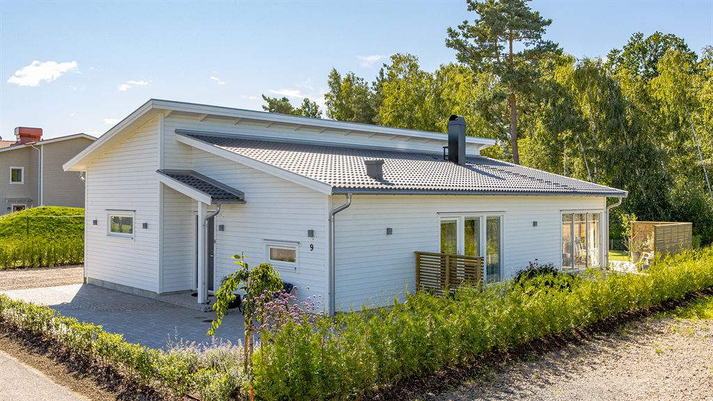 Vitt enplanshus med grått tak och entrétak V18058 från Varbergshus